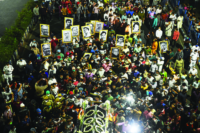 EDITORS NOTE: Graphic content / Mourners gather around a vehicle carrying the body of late Indian actor Soumitra Chatterjee during a funeral procession to a crematorium in Kolkata on November 15, 2020. - Indian actor Soumitra Chatterjee has died on November 15, 2020, at the age of 85 in a hospital in Kolkata, where he was admitted on October 6 after being tested positive with Covid-19 coronavirus. (Photo by Dibyangshu SARKAR / AFP)