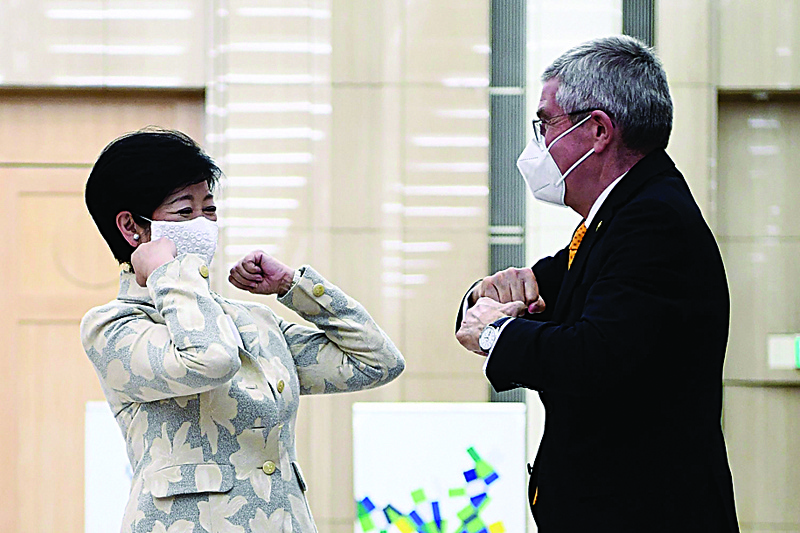 Tokyo Governor Yuriko Koike (L) bumps elbow with International Olympic Committee (IOC) president Thomas Bach during their meeting in Tokyo on November 16, 2020. (Photo by CHARLY TRIBALLEAU / AFP)