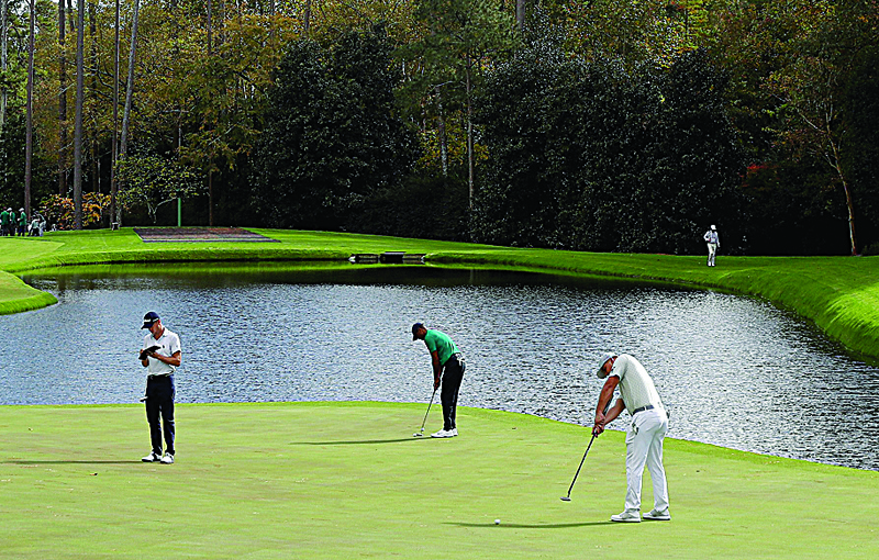 AUGUSTA, GEORGIA - NOVEMBER 09: Tiger Woods of the United States and Bryson DeChambeau of the United States putt on the 16th green as Justin Thomas of the United States looks on during a practice round prior to the Masters at Augusta National Golf Club on November 09, 2020 in Augusta, Georgia.   Jamie Squire/Getty Images/AFPn== FOR NEWSPAPERS, INTERNET, TELCOS &amp; TELEVISION USE ONLY ==