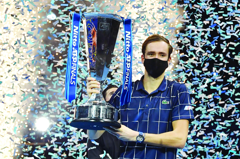 Russia's Daniil Medvedev wearing a protective face covering to combat the spread of the coronavirus, poses with the winner's trophy after his 4-6, 7-6, 6-4 win over Austria's Dominic Thiem in their men's singles final match on day eight of the ATP World Tour Finals tennis tournament at the O2 Arena in London on November 22, 2020. - Daniil Medvedev came from a set down to beat Dominic Thiem 4-6, 7-6 (7/2), 6-4 and win the ATP Finals title in London on Sunday for the biggest tournament victory of his career. (Photo by Glyn KIRK / AFP)