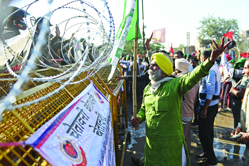 KUNDLI: Farmers react as police block a street to impede them from marching to New Delhi to protest against the central government’s recent agricultural reforms at the Delhi-Haryana border in Kundli on Friday.— AFP