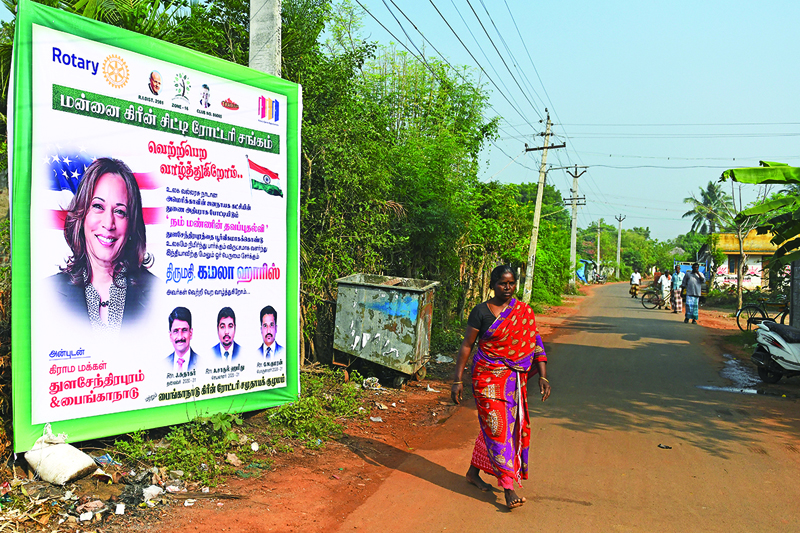 A woman walks past a poster of US Democratic vice-presidential candidate, Kamala Harris, at her ancestral village of Thulasendrapuram in the southern Indian state of Tamil Nadu on November 3, 2020. (Photo by Arun SANKAR / AFP)