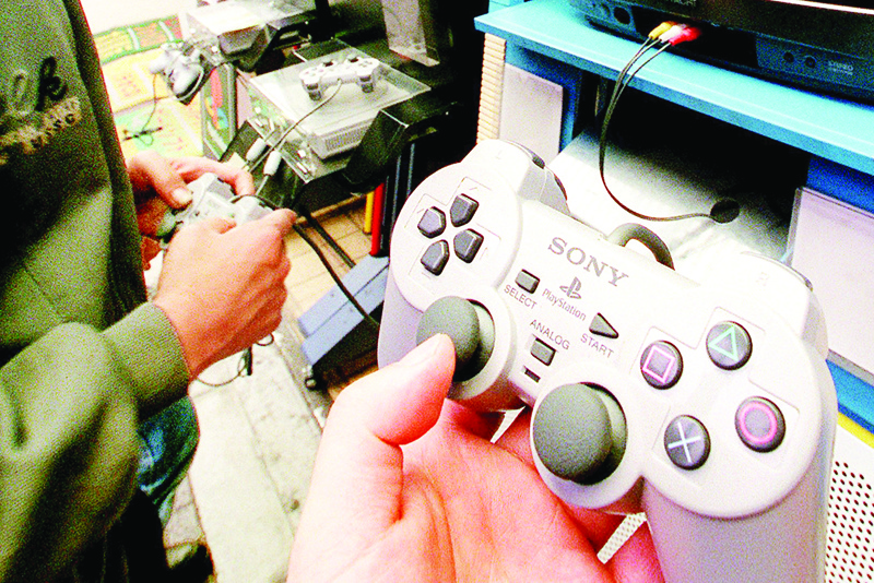 (FILES) This file photo taken on May 8, 1998 shows a youth using a Sony Playstation console at a computer shop in Tokyo's Akihabara electronic shops district. - Sony launches its PlayStation 5 console on November 12, 2020 angling for a mega-hit, and with the Japanese firm increasingly dependent on the lucrative gaming sector there is little room for error. (Photo by YOSHIKAZU TSUNO / AFP) / TO GO WITH Games-consoles-IT-lifestyle-Asia-USA,FOCUS by Mathias CENA