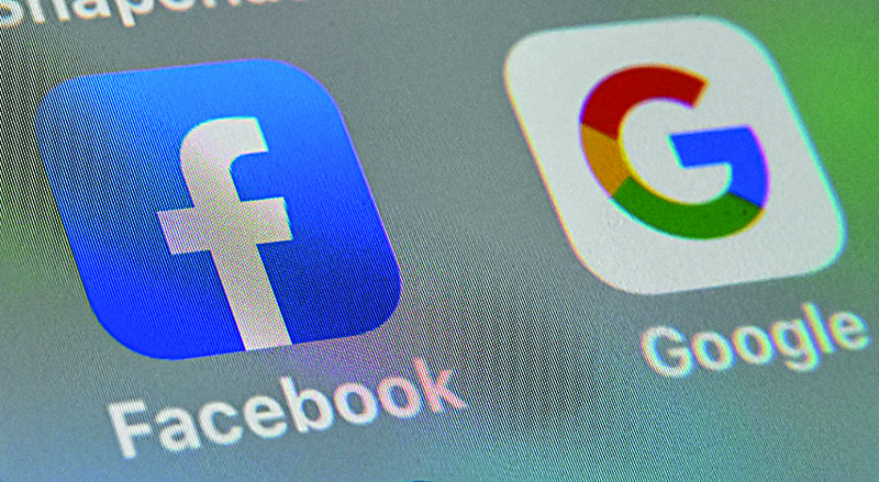 (FILES) In this file photo illustration taken on October 01, 2019, shows the logos of mobile apps  Facebook and Google displayed on a tablet in Lille France. - Facebook and Google have extended their bans on political ads in the US amid misinformation circulated aimed at bolstering claims by President Donald Trump of fraud in his loss to Joe Biden. (Photo by DENIS CHARLET / AFP)