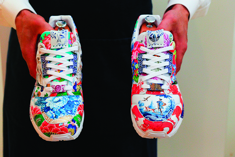 (FILES) In this file photo an art handler from Sotheby's holds one-of-a-kind Sneakers by Adidas and Meisse named the ZX8000 Porcelain, during a preview at Sotheby's Auction House on December 4, 2020 in New York City. - A unique pair of sneakers designed by Adidas and German porcelain maker Meissen that could become the first to fetch $1 million went on sale at a Sotheby's auction on December 7, 2020. The leather shoes -- based on Adidas's popular ZX8000 model and painted by craftsmen from Meissen -- are tipped to set a new record for a pair of trainers. (Photo by Kena Betancur / AFP)