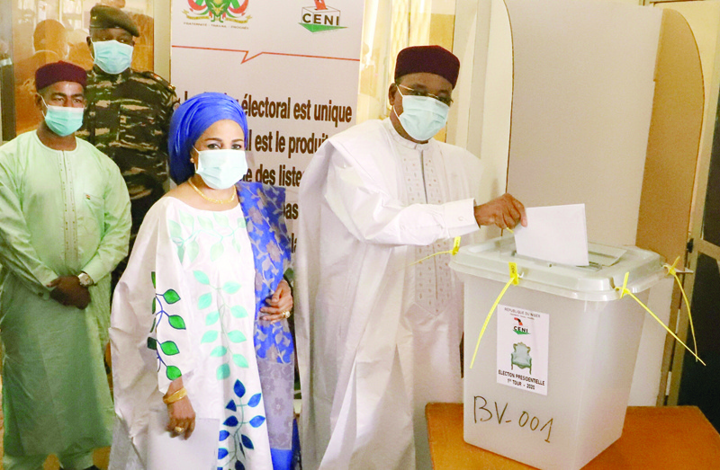 Niger's outgoing president Mahamadou Issoufou (R) cast his ballot at a polling station in Niamey on December 27, 2020 during Niger's presidential and legislative elections. - Voters in the Sahel state of Niger go to the polls on December 27, 2020 for an election that could seal the country's first-ever peaceful handover between elected presidents, despite a bloody jihadist insurgency. (Photo by Issouf SANOGO / AFP)