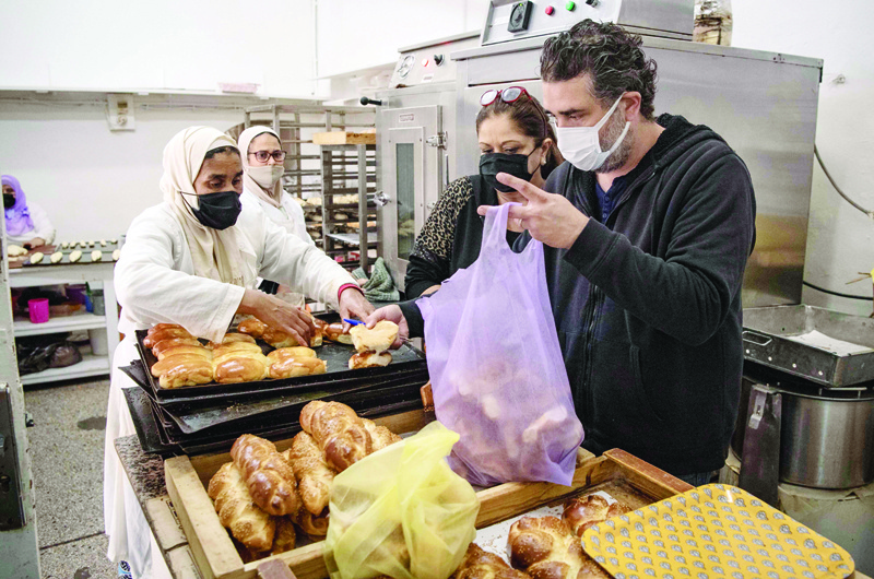 Members of the Moroccan Jewish community (R) buy pastries at a kosher shop in the western Moroccan port city of Casablanca, on December 11, 2020 - After the United Arab Emirates, Bahrain and Sudan, Morocco is the fourth Arab country since August to commit to establishing diplomatic relations with the Israel.nIn the 1950s and 60s, Jews from Iraq, Yemen and Morocco migrated to the Jewish state, where key posts were in the hands of Ashkenazi Jews, who hail from Europe. (Photo by FADEL SENNA / AFP)