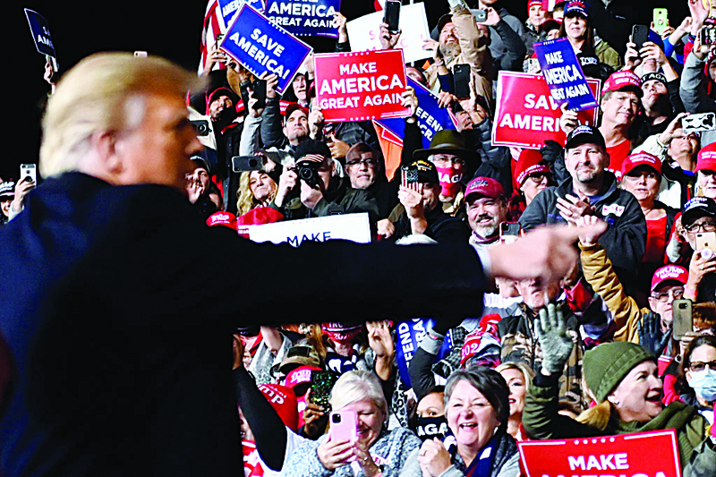 TOPSHOT - Supporters cheer as US President Donald Trump gestures after speaking during a rally to support Republican Senate candidates at Valdosta Regional Airport in Valdosta, Georgia on December 5, 2020. - President Donald Trump ventures out of Washington on Saturday for his first political appearance since his election defeat to Joe Biden, campaigning in Georgia where two run-off races will decide the fate of the US Senate. (Photo by Andrew CABALLERO-REYNOLDS / AFP)