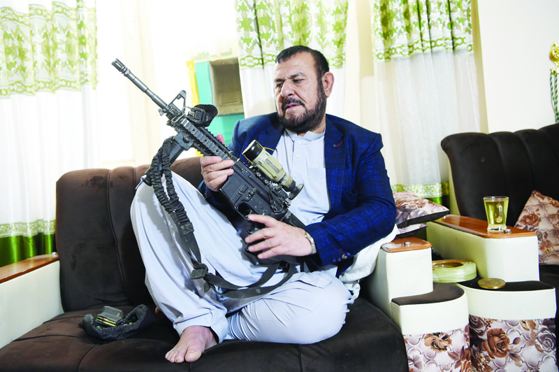 In this photo taken on September 28, 2020, former police chief of the Panjwai district, Sultan Mohammad Hakimi, poses with a gun during an interview with AFP in Panjwai. - Despite the bloodshed he has witnessed throughout his career, Hakimi has made it a personal mission to give ex-Taliban fighters, commanders and officials the chance to reintegrate into village life. (Photo by WAKIL KOHSAR / AFP) / TO GO WITH Afghanistan-conflict-Taliban-rehabilitation,FOCUS by Elise Blanchard and Rashid Durrani