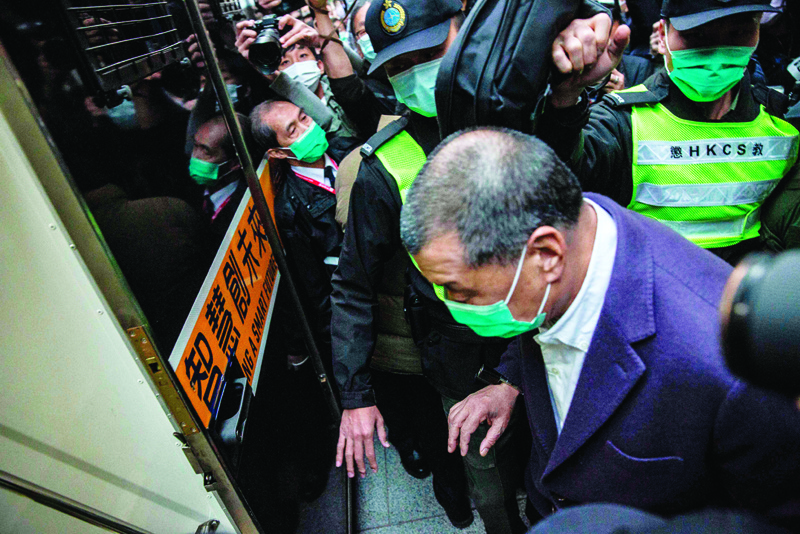 Media tycoon Jimmy Lai (C) is escorted onto a prison van outside the Court of Final Appeal in Hong Kong on December 31, 2020, after he was ordered back to jail as the city's highest court granted prosecutors an appeal against his bail. (Photo by ISAAC LAWRENCE / AFP)