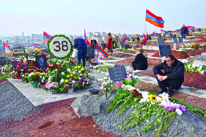 TOPSHOT - People visit the graves of their relatives killed during the Karabakh conflict in Yerevan on December 12, 2020. - Separatist officials in the breakaway region of Nagorno-Karabakh said Saturday that three fighters were wounded in a skirmish with Azerbaijani forces, undermining a recent peace deal brokered by Russia. (Photo by Karen MINASYAN / AFP)