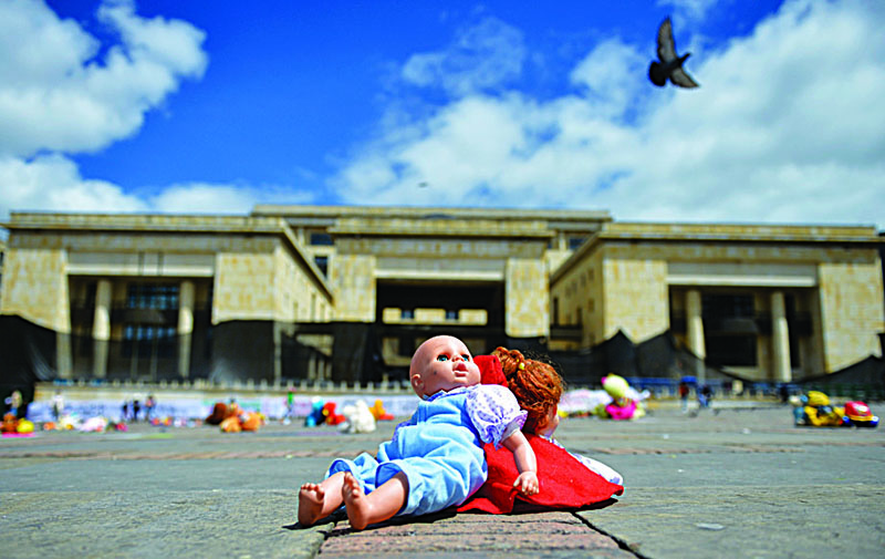 Dolls are placed at the Bolivar square during a demonstration against child abuse in Bogota, on November 30, 2020. - A thousand cuddly toys were scattered around Bogota's main square on Monday with a message denouncing the sexual violence that punishes 37 children in Colombia every day. (Photo by RAUL ARBOLEDA / STAFF / AFP)