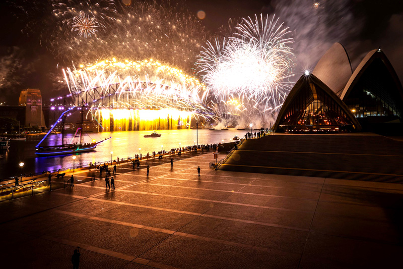 A deserted Sydney Opera House forecourt can be seen in front of fireworks exploding from the Sydney Harbour Bridge during New Year celebrations in central Sydney on January 1, 2021. (Photo by DAVID GRAY / AFP)