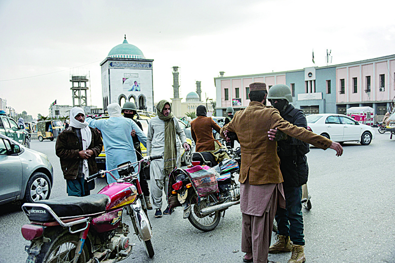 Afghan policemen search people at a checkpoint at the Chawk-e-Shahidan in Kandahar on December 13, 2020. - Dozens of Taliban fighters were killed in fierce overnight fighting between Afghan forces and militants who attacked multiple checkpoints in the insurgent bastion of Kandahar, officials said on December 13. (Photo by JAVED TANVEER / AFP)