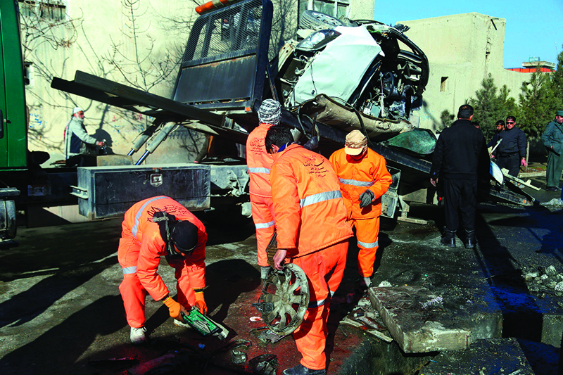 Municipal workers clean up debris at the site of a bomb attack in Kabul on December 22, 2020. - Four doctors who worked at an Afghan prison with hundreds of Taliban inmates were among five people killed on December 22 when a bomb attached to their car exploded, police said. (Photo by Zakeria HASHIMI / AFP)