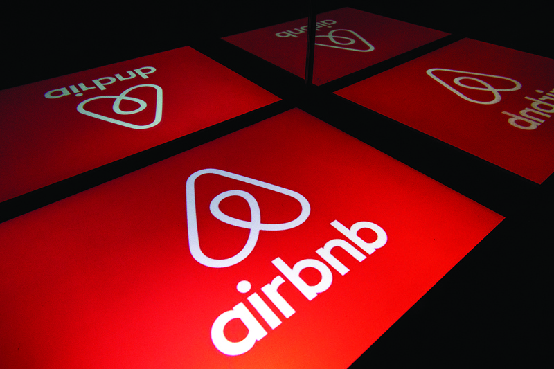 FILES) In this file illustration photo taken on November 22, 2019 shows the logo of the online lodging service Airbnb displayed on a tablet in Paris. - Airbnb is seeking to raise some $2.6 billion in its upcoming share offering, which could give the home-sharing giant a valuation as high as $35 billion, an updated regulatory filing showed on December 1, 2020. The California group said its initial public offering would include some 51.9 million shares in a range of $44 to $50. (Photo by Lionel BONAVENTURE / AFP)
