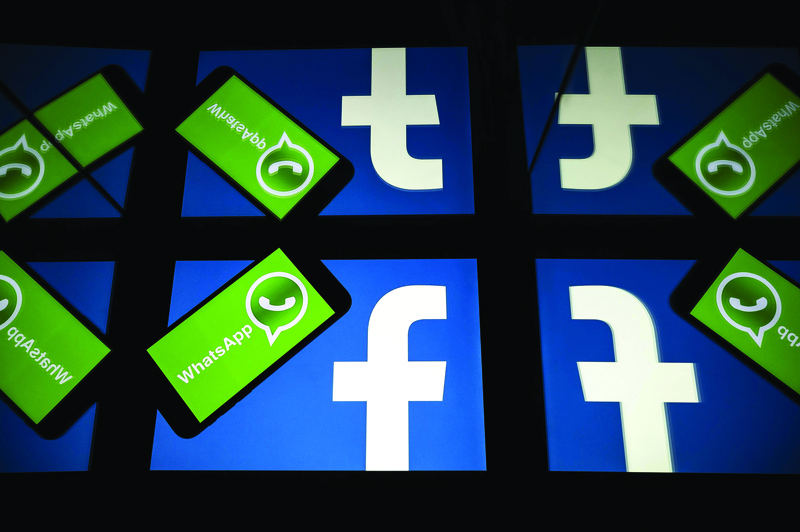 (FILES) In this file photo taken on October 05, 2020 the logo of US social network Facebook and mobile messaging service WhatsApp are seen on the screens of a smartphone and a tablet in Toulouse, southwestern France. - US federal and state antitrust enforcers filed suit against Facebook on December 9, 2020 claiming the social media giant abused its dominant position with its acquisitions of messaging services Instagram and WhatsApp. (Photo by Lionel BONAVENTURE / AFP)