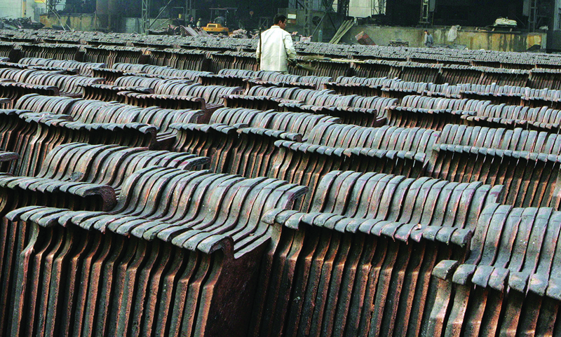 (FILES) In this file photo taken on November 23, 2005 A worker inspects newly smelted copper anode sheets for delivery at the Dachang Copper companies refinery, in Shanghai on November 23, 2005. - China, a major consumer of raw materials, is seeking to position itself as an international marketplace for the brokerage of these assets and has just launched a futures contract on the hot copper market. (Photo by MARK RALSTON / AFP)
