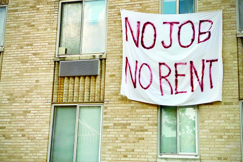 (FILES)In this file photo taken on August 09, 2020, a banner against renters eviction reading ìno job, no rentî is displayed on a controlled rent building in Washington, DC. - New applications for US jobless benefits fell by 89,000 last week after two weeks of increases but remain high as Covid-19 cases have spiked, according to government data Thursday. Applications fell to 803,000 in the week ended December 19 from an upwardly-revised 892,000 in the prior week, according to the seasonally-adjusted Labor Department data.That was far below the level economists had been expecting, although analysts warn that the reports can be erratic due to seasonal adjustment errors around the holidays. (Photo by Eric BARADAT / AFP)