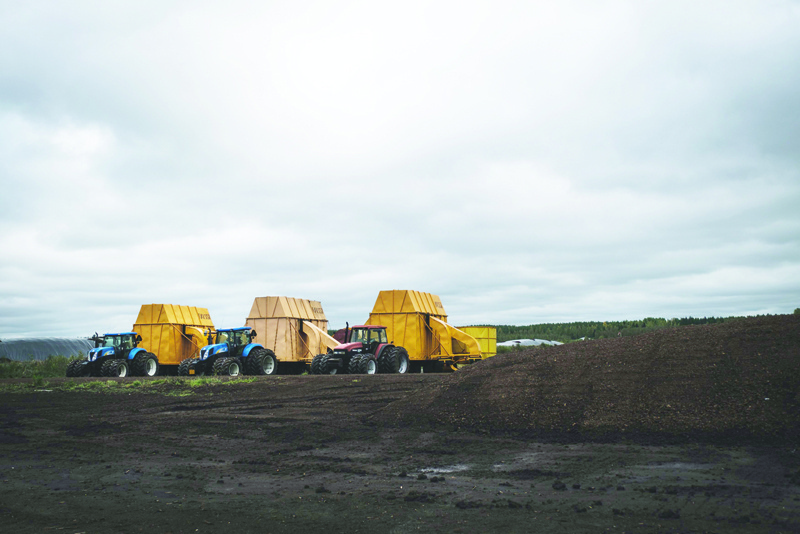Tractors and peat faming machineries are lined up in Taisto Raussi's peat fields in Sippola, Finland, on September 22, 2020. - On a barren expanse of bog in southeast Finland the size of 180 football pitches, Taisto Raussi's yellow harvester hoovers up a thin layer of rich peat and deposits it into a heap, to be sold as fuel.nThe Nordic country is by far the EU's largest burner of peat and is mired in a divisive battle over the energy source which is more polluting than coal and can cause catastrophic environmental damage. (Photo by Alessandro RAMPAZZO / AFP)