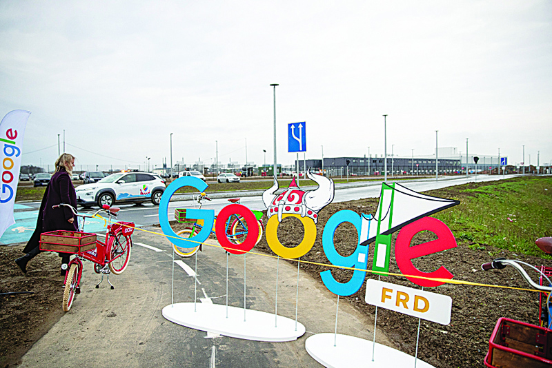 A woman passes by a google themed barrier in front of a google data center on November 30, 2020 in Fredericia, Denmark. (Photo by Frank Cilius / Ritzau Scanpix / AFP) / Denmark OUT