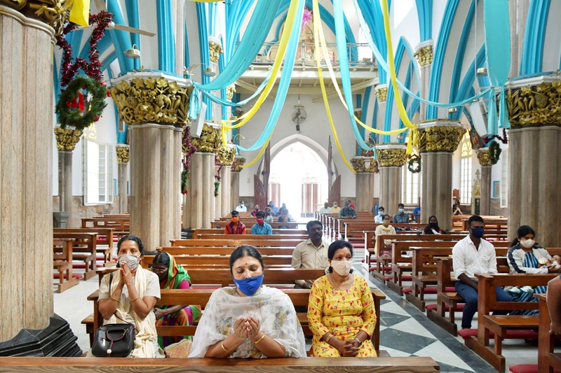 Christian devotees wearing facemasks as a preventive measure against the Covid-19 coronavirus offer prayers at St Maryís Basilica on the eve of Christmas in Bangalore on December 24, 2020. (Photo by Manjunath Kiran / AFP)