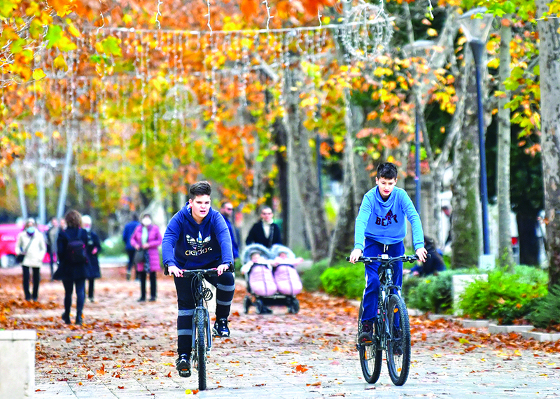 Children ride bicyles and citizens of the Southern-Bosnian town of Mostar walk on city's main promenade, on December 7, 2020. - Mostar is the only Bosnian city that has not held local elections in 12 years. Split into Croat and Bosniak zones by the Dayton Peace Agreement, which ended Bosnia's war 25 years ago, the town is a symbol of the broken politics that has haunted the Balkan state ever since. With two nationalist parties in power and unable to agree on voting rules, Mostar has not held local elections since 2008. (Photo by ELVIS BARUKCIC / AFP)