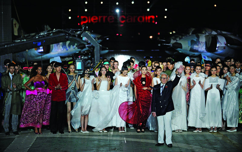 (FILES) A file photo taken on May 13, 2011 shows French fashion icon Pierre Cardin (centre R) waving after his fashion show on board the former-Soviet aircraft carrier Kiev at the Tianjin Binhai Aircraft Carrier Theme Park outside Tianjin in northeastern China. - French fashion designer Pierre Cardin, hailed for his visionary creations but also for bringing stylish clothes to the masses, died on December 29, 2020 aged 98, his family told AFP. Cardin who was born in Italy in 1922 but emigrated to France as a small child, died in a hospital in Neuilly in the west of Paris, his family said. (Photo by PETER PARKS / AFP)