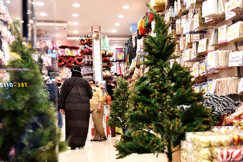 People walk past christmas decorations displayed for sale at a gift shop in Saudi Arabia's capital Riyadh on December 7, 2020. - Until barely three years ago, such items were almost impossible to be openly sold in Saudi Arabia, where authorities have clipped the powers of the clerical establishment long notorious for enforcing Islamic traditions. For decades, Christmas sales were largely underground, and Christians from the Philippines, Lebanon and other countries celebrated the festival behind closed doors or in expat enclaves. (Photo by FAYEZ NURELDINE / AFP)