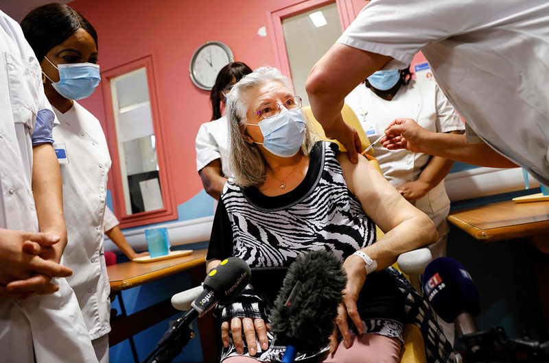 TOPSHOT - Mauricette, a French 78-year-old woman, receives a dose of the Pfizer-BioNTech Covid-19 vaccine at Rene-Muret hospital in Sevran, on the outskirts of Paris, on December 27, 2020. - Mauricette is the first person to receive a dose of the Covid-19 vaccine in France against Covid-19, as countries of the European Union began a vaccine rollout. (Photo by Thomas SAMSON / various sources / AFP)