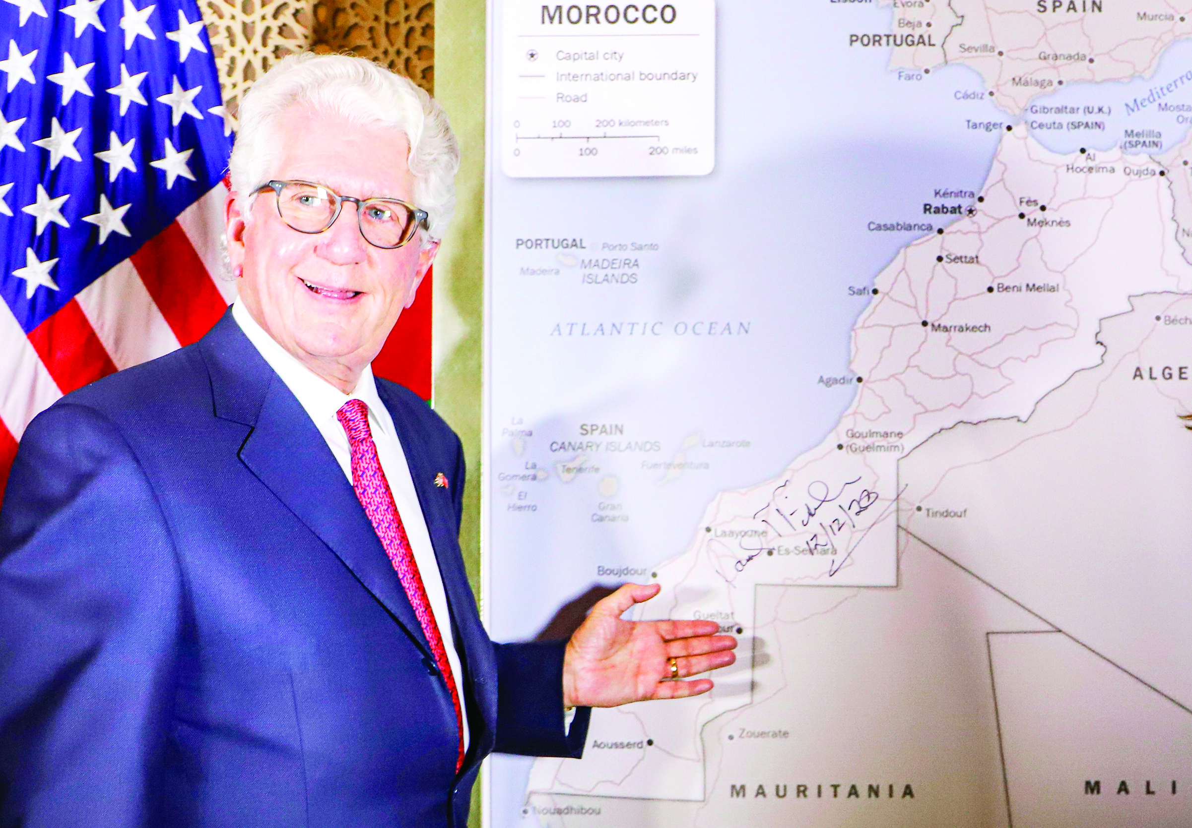 David T. Fischer, US Ambassador to the Kingdom of Morocco, standing before a US State Department-authorised map of Morocco recognising the internationally-disputed territory of the Western Sahara (bearing a signature by Fischer) as a part of the North African kingdom, in Morocco's capital Rabat on December 12, 2020. (Photo by - / AFP)