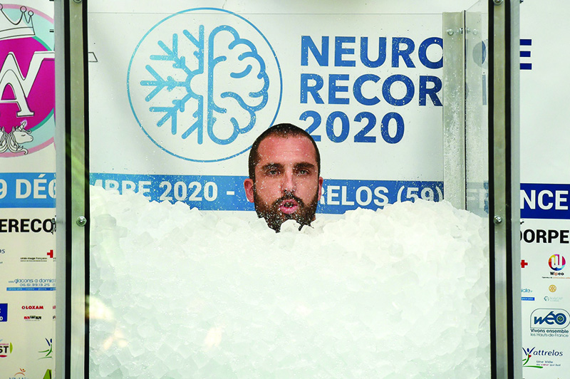 French Romain Vandendorpe looks on as he tries to break the world record for the longest full body contact with ice cubes, in Wattrelos, northern France, on December 19, 2020. (Photo by FRANCOIS LO PRESTI / AFP)
