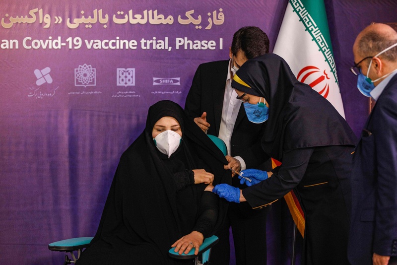 A woman receives an injection during the first trial phase of a locally-made Iranian vaccine for COVID-19 coronavirus disease in Iran's capital Tehran on December 29, 2020. (Photo by - / AFP)
