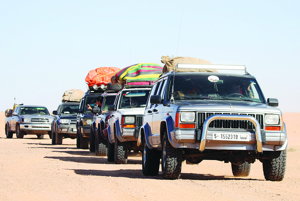 Libyans take part in a 4x4 tourism trip in a desert area near al-Shuwayrif town, some 400 Km southwest of the capital, on December 3, 2020. - In 2010, 110,000 foreign tourists visited Libya, generating $ 40 million, a figure that has dropped to zero since 2011 due to the political chaos and insecurity following the fall of the Moamer Kadhafi regime in 2011. (Photo by Mahmud TURKIA / AFP)