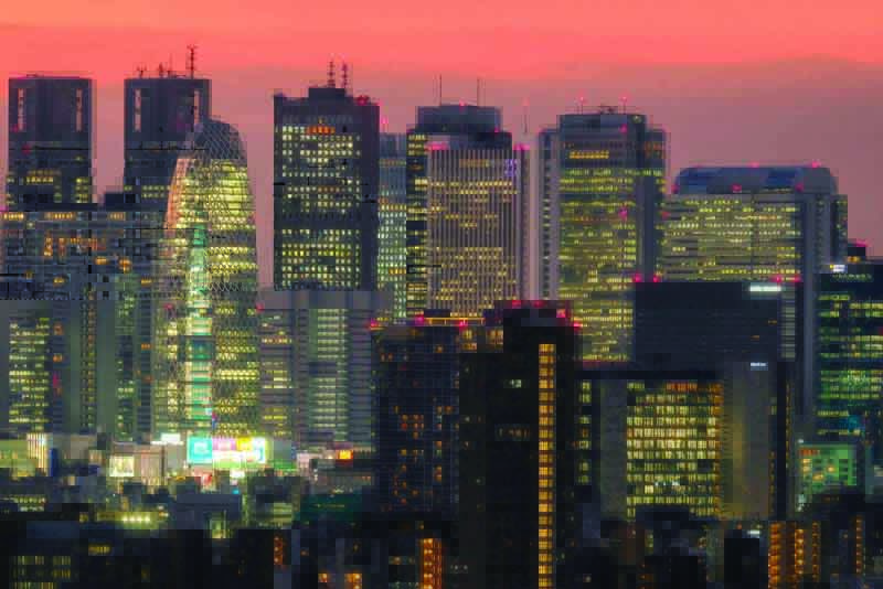 Skyscrapers in Tokyo's Shinjuku area are seen during sunset on December 1, 2020. (Photo by Kazuhiro NOGI / AFP)