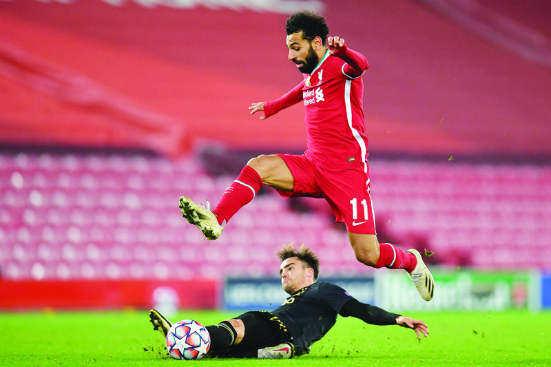 Liverpool's Egyptian midfielder Mohamed Salah is tackled by Ajax's Argentinian defender Nicolas Tagliafico during the UEFA Champions League 1st round Group D football match between Liverpool and Ajax at Anfield  in Liverpool, north west England on December 1, 2020. (Photo by Paul ELLIS / POOL / AFP)