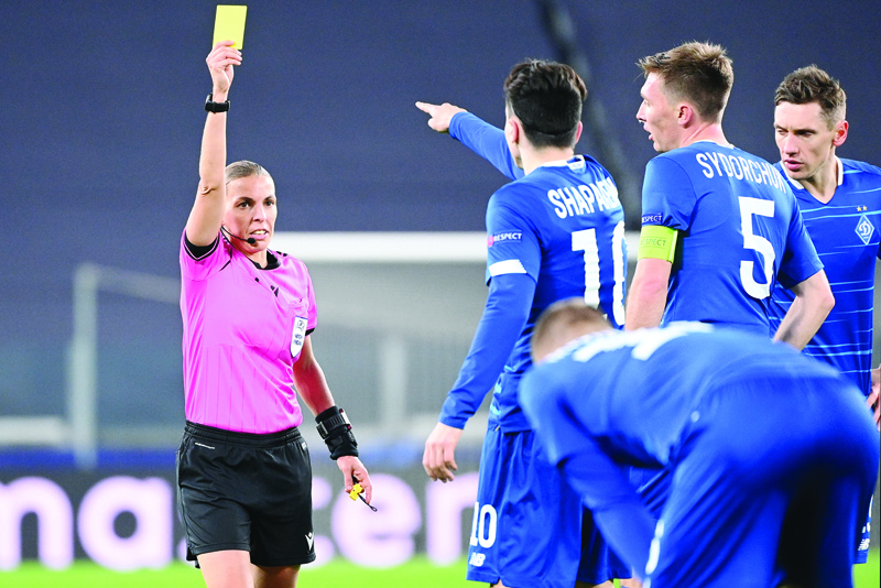 French referee Stephanie Frappart gives a yellow card to Dynamo Kiev's Ukrainian midfielder Nicholas Shaparenko (C) during the UEFA Champions League Group G football match Juventus vs Dynamo Kiev on December 2, 2020 at the Juventus stadium in Turin. (Photo by Vincenzo PINTO / AFP)