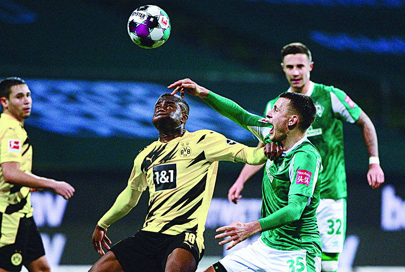 Bremen's German midfielder Maximilian Eggestein and Dortmund's German forward Youssoufa Moukoko (L) vie for the ball during the German first division Bundesliga football match Werder Bremen v Borussia Dortmund in Bremen, western Germany, on December 15, 2020. (Photo by Patrik Stollarz / various sources / AFP) / DFL REGULATIONS PROHIBIT ANY USE OF PHOTOGRAPHS AS IMAGE SEQUENCES AND/OR QUASI-VIDEO