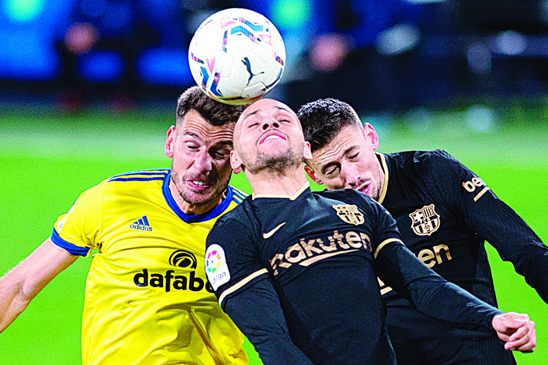 Cadiz' Swiss defender Jean-Pierre Rhyner (L) vies with Barcelona's Danish forward Martin Braithwaite (C) and French defender Clement Lenglet during the Spanish League football match between Cadiz and Barcelona at the Ramon de Carranza stadium in Cadiz on December 5, 2020. (Photo by JORGE GUERRERO / AFP)