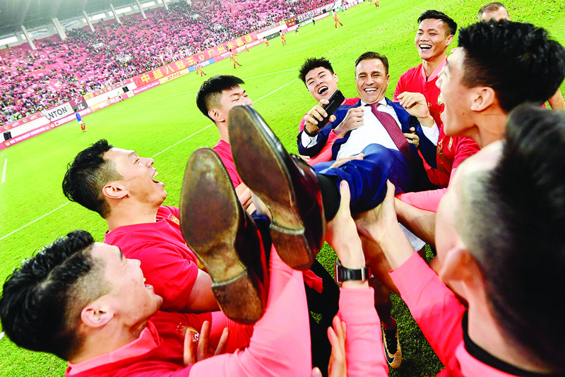 (FILES) This file photo taken on December 1, 2019 shows players of Guangzhou Evergrande lifting up their head coach Fabio Cannavaro in celebration after defeating Shanghai Shenhua to win the Chinese Super League (CSL) football championship in Guangzhou, in China's southern Guangdong province., - Cannavaro's reign at Guangzhou Evergrande appears to be all but over after the eight-time Chinese Super League champions ended a disappointing 2020 season under the Italian without silverware. (Photo by STR / AFP)