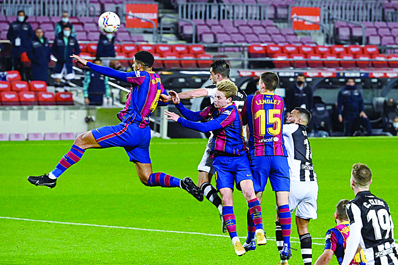 Barcelona's Uruguayan defender Ronald Araujo (L) jumps for the ball  during the Spanish league football match between FC Barcelona and Levante UD at the Camp Nou stadium in Barcelona on December 13, 2020. (Photo by LLUIS GENE / AFP)