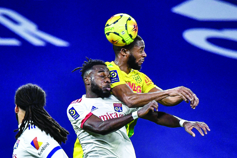 Lyon's Ivorian forward Maxwel Cornet (C) vies with Nantes' French forward Marcud Coco (R) during the French L1 football match between Lyon (OL) and FC Nantes at the Groupama stadium in Decines-Charpieu near Lyon on December 23, 2020. (Photo by JEFF PACHOUD / AFP)