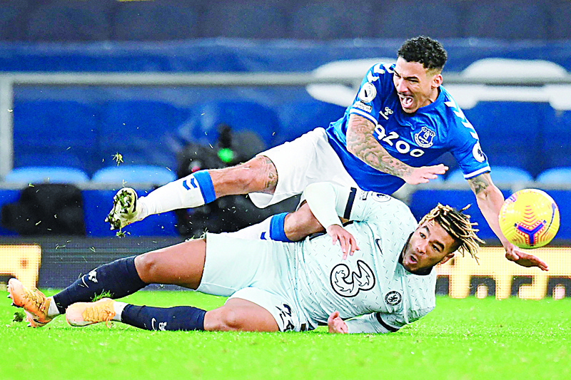 Chelsea's English defender Reece James slides in to foul Everton's Brazilian midfielder Allan during the English Premier League football match between Everton and Chelsea at Goodison Park in Liverpool, north west England on December 12, 2020. (Photo by PETER POWELL / POOL / AFP) / RESTRICTED TO EDITORIAL USE. No use with unauthorized audio, video, data, fixture lists, club/league logos or 'live' services. Online in-match use limited to 120 images. An additional 40 images may be used in extra time. No video emulation. Social media in-match use limited to 120 images. An additional 40 images may be used in extra time. No use in betting publications, games or single club/league/player publications. /