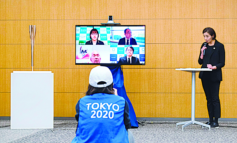 Tokyo 2020 employee Hanae Ito (R) and representatives from four prefectures, Iwate, Miyagi, Fukushima and Tokyo who are displayed on a remote television, attend a press conference to announce details of the local municipalities participating in the Tokyo 2020 Olympic Torch Relay in 2021 and their respective celebration venues, in Tokyo on December 15, 2020. (Photo by Kazuhiro NOGI / AFP)