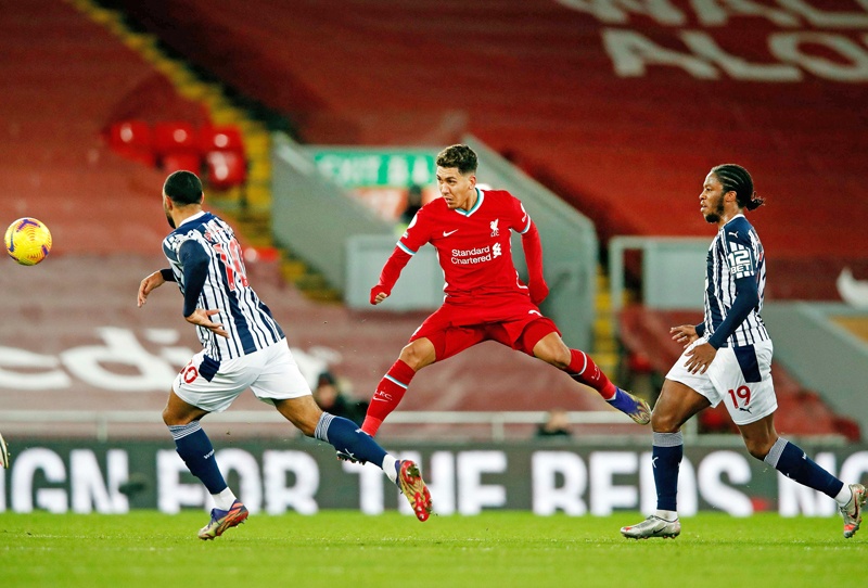 TOPSHOT - Liverpool's Brazilian midfielder Roberto Firmino (C) plays the ball during the English Premier League football match between Liverpool and West Bromwich Albion at Anfield in Liverpool, north west England on December 27, 2020. (Photo by Clive Brunskill / POOL / AFP) / RESTRICTED TO EDITORIAL USE. No use with unauthorized audio, video, data, fixture lists, club/league logos or 'live' services. Online in-match use limited to 120 images. An additional 40 images may be used in extra time. No video emulation. Social media in-match use limited to 120 images. An additional 40 images may be used in extra time. No use in betting publications, games or single club/league/player publications. /