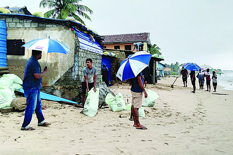 Residents prepare sand bags to protect their homes ahead of cyclone Burevi landfall in Sri Lanka's north-eastern coast, in Trincomalee on December 2, 2020. - Sri Lanka shut schools in several areas and rescue workers were deployed in southern India on D2 ahead of the second cyclone to buffet the region in a week. (Photo by STR / AFP)