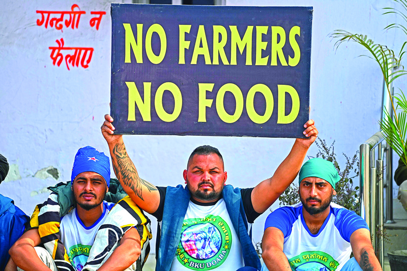 A farmer holds a placard during a nationwide general strike to protest against the recent agricultural reforms at the Delhi-Haryana state border in Singhu on December 8, 2020. (Photo by Sajjad HUSSAIN / AFP)