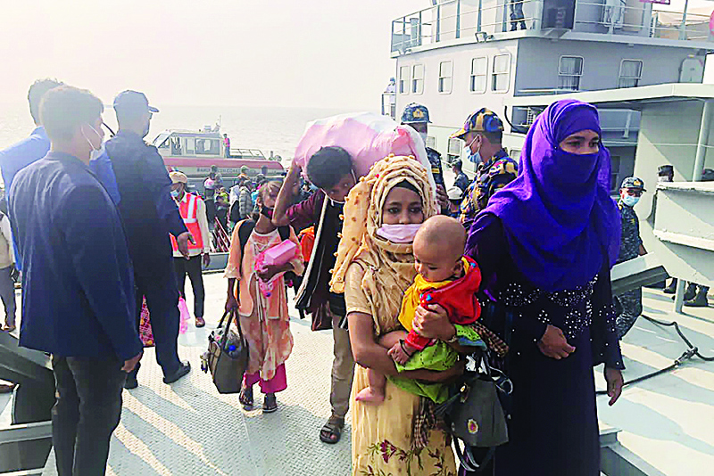 Rohingya refugees disembark from a Bangladesh Navy ship to the island of Bashar Char in Noakhali on December 4, 2020. - Bangladeshi authorities set more than 1,640 Rohingya refugees on the final leg of their journey to an allegedly dangerous island on December 4, in the first phase of a controversial planned relocation of 100,000 people. (Photo by Stringer / AFP)
