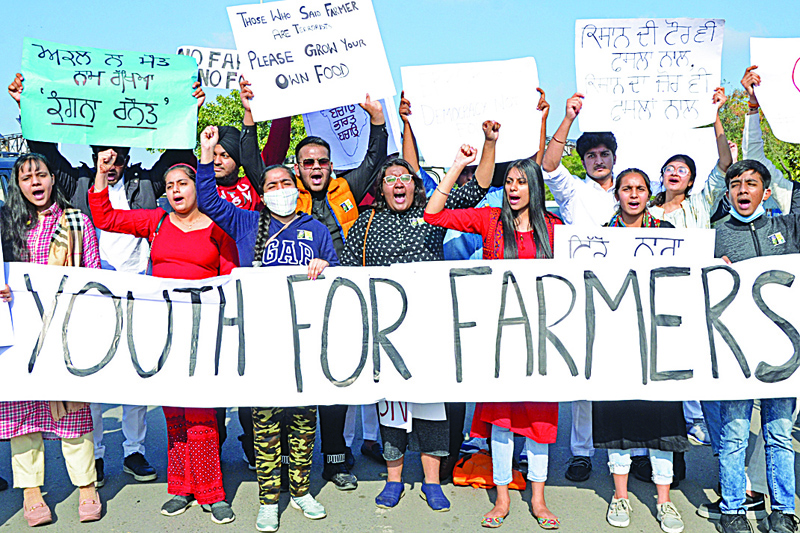 Students hold placards as they shout slogans in support of farmers during a protest against the recent agricultural reforms in Amritsar on December 12, 2020. (Photo by Narinder NANU / AFP)