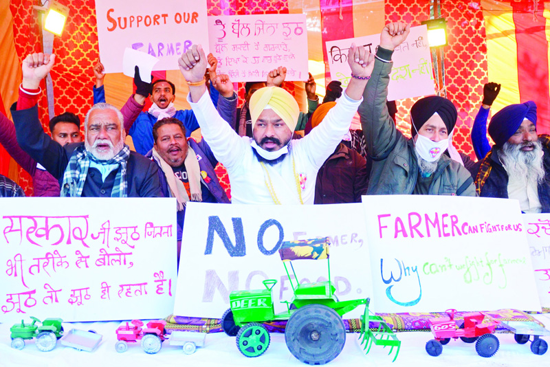 Members of Shaheed Bhagat Singh Welfare Club shout slogans as they take part in a sit-in hunger strike in support of farmers protesting against the central governmentís recent agricultural reforms, in Amritsar on December 19, 2020. (Photo by Narinder NANU / AFP)